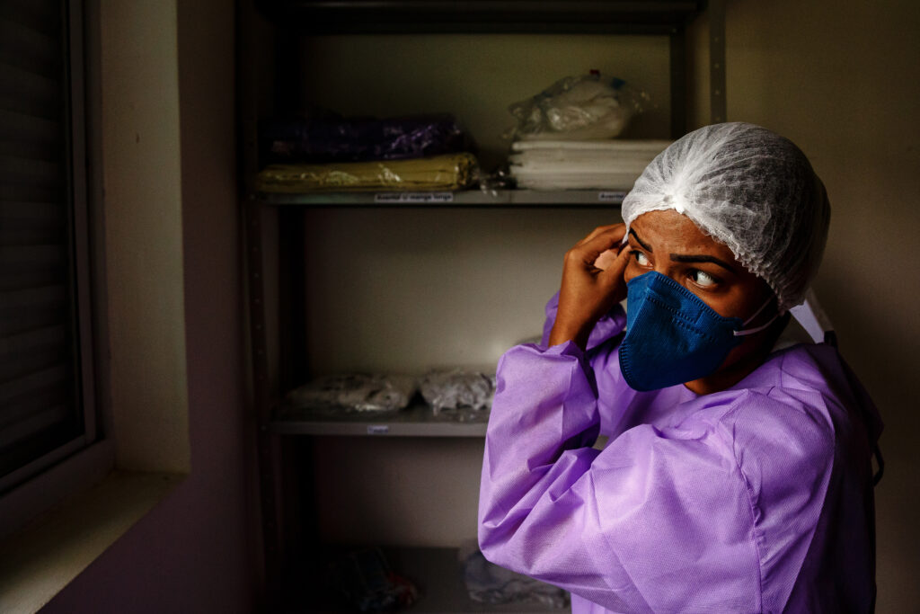 MSF health worker wears personal protective equipment before entering an MSF care center for mild and moderate cases of COVID-19 in Brazil.